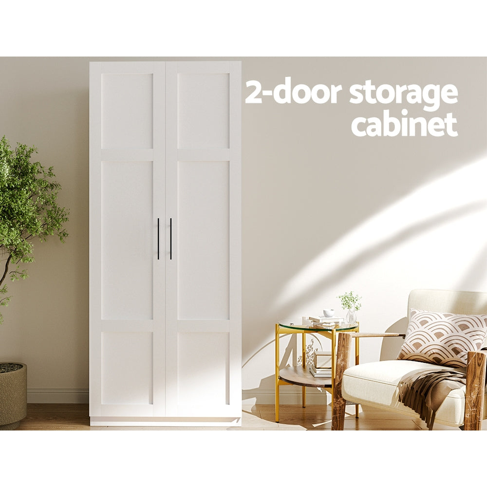 White tall two-door storage cabinet in living room with potted tree, armchair and side table; text: 2-door storage cabinet