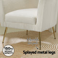 White teddy armchair detail of gold splayed legs on patterned rug; 