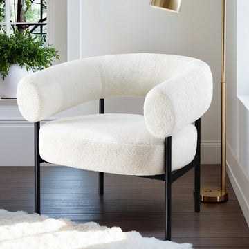 White teddy fabric barrel armchair with curved wraparound backrest on black metal frame in lifestyle room