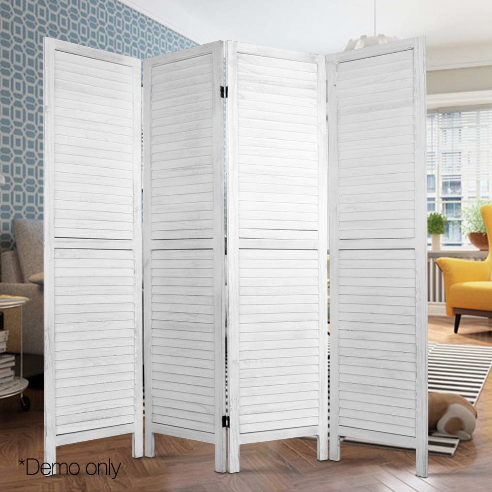 White-washed 4-panel louvered wood room divider in lifestyle room with blue geometric wallpaper and yellow armchair
