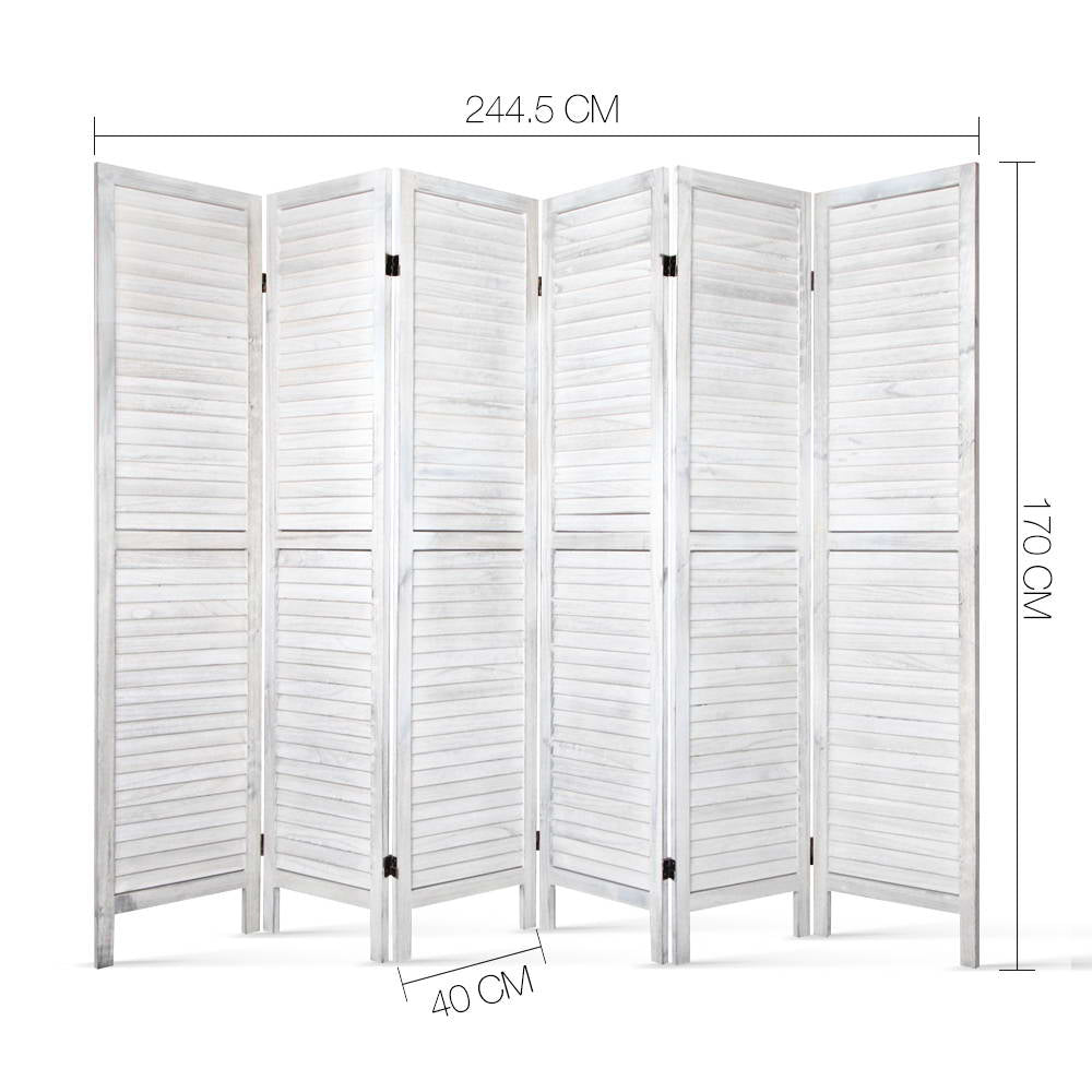 White-washed 6-panel louvered wood room divider in lifestyle room with ficus tree bamboo wall panel and cushions on cream rug