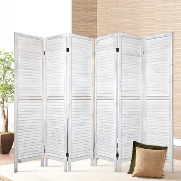 White-washed 6-panel louvered wood room divider in lifestyle room with ficus tree bamboo wall panel and cushions on cream rug