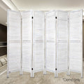 White-washed 6-panel louvered wood room divider in lifestyle room with marble tile floor and dark built-in shelving