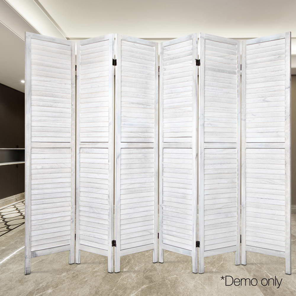 White-washed 6-panel louvered wood room divider in lifestyle room with marble tile floor and dark built-in shelving