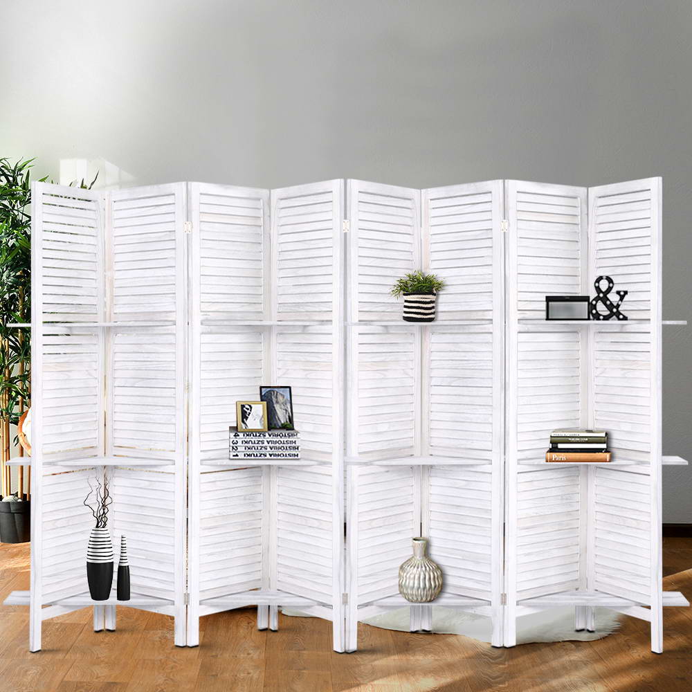 White-washed 6-panel louvered wood room divider with 3-tier shelves in grey lifestyle room with plant vases and books