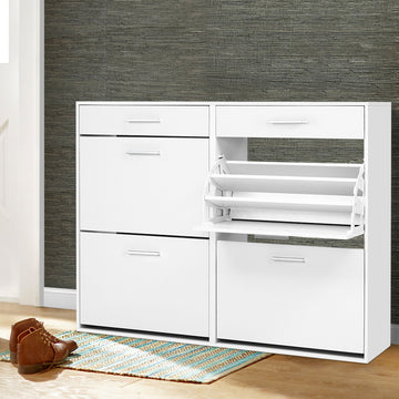 White wide shoe cabinet two drawers and four flip-out compartments right middle tray open in hallway with textured wallpaper