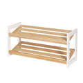 Two-tier shoe rack with white MDF side panels and natural pine slatted shelves, empty, angle view
