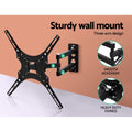 Full-motion X-pattern TV bracket three-arm design on orange wall joints 1-3 smooth movement and heavy-duty fixings