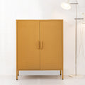 Mustard yellow two-door metal locker cabinet with bar handles and louvre vents beside chrome floor lamp